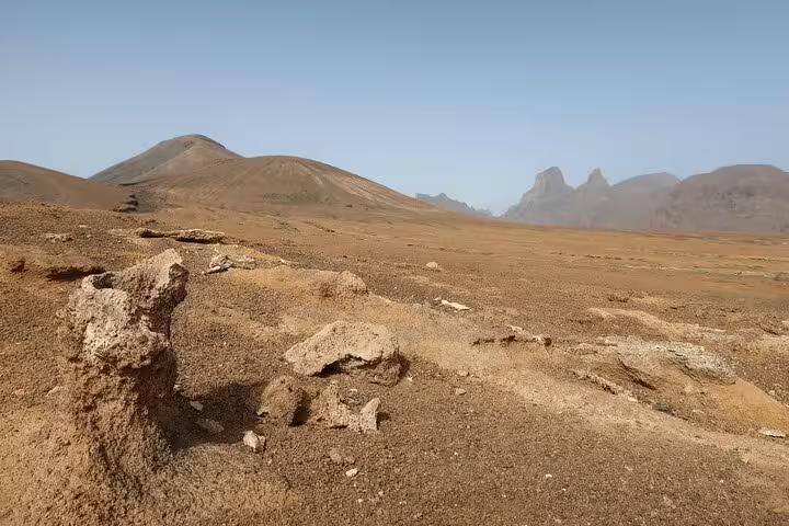 Rocky terrain and distant peaks in São Nicolau's Praia Branca, ideal for adventurous hiking tours.