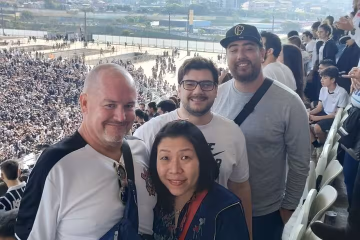 Group photo in a packed São Paulo stadium before joining a local soccer game, authentic football fan experience