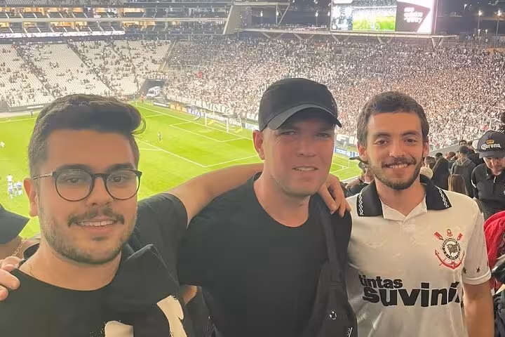 Guests with local guide in the stands overlooking the pitch at a São Paulo soccer match on a join-a-game tour