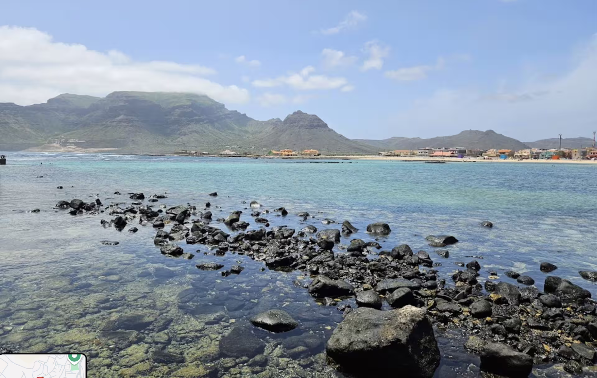 Idyllic São Vicente coastline with turquoise waters and rocky shore, set against lush Monte Verde backdrop, perfect for tours.
