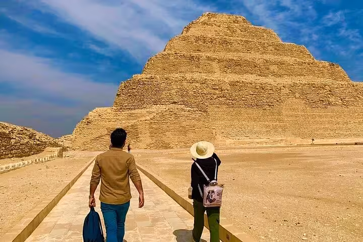 Travelers walk toward Saqqara Step Pyramid on a Memphis, Dahshur and Saqqara day tour from Cairo