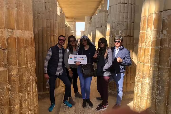 Travelers inside Saqqara temple corridor with columns, part of Pyramids, Memphis and Sakkara day tour from Cairo