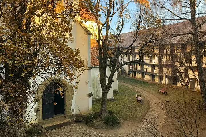 Medieval Saxon fortification courtyard with half-timbered gallery and Gothic chapel entrance in autumn, Brasov