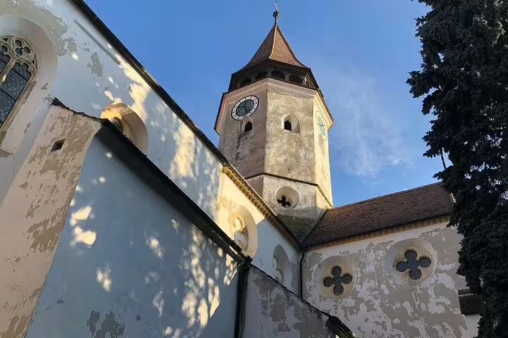 Medieval Saxon church tower with clock and Gothic rose windows in Brasov, Romania