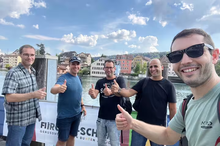 Friends posing by the Rhine in Schaffhausen during a self-guided scavenger hunt and sightseeing tour in Switzerland