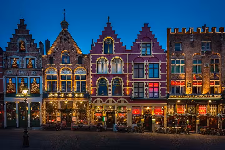 Illuminated Markt Square guildhouses in Bruges at night, highlight of Schiphol Airport to Bruges transfer