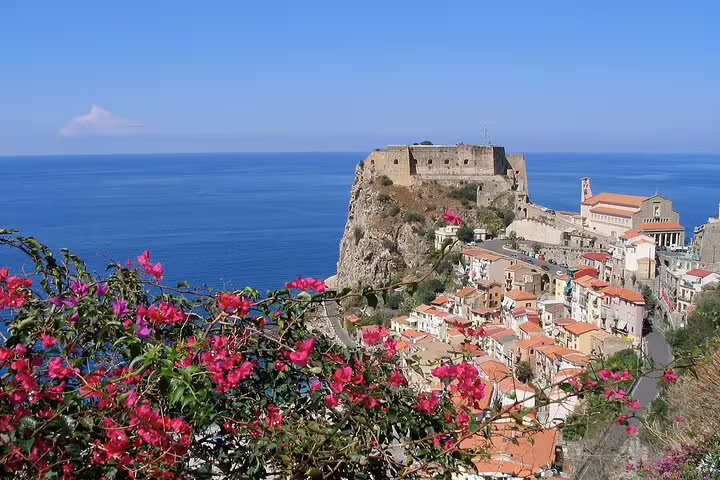 Panoramic view of Scilla’s Castello Ruffo, pastel houses and Tyrrhenian Sea from a flowered terrace on a guided Calabria tour