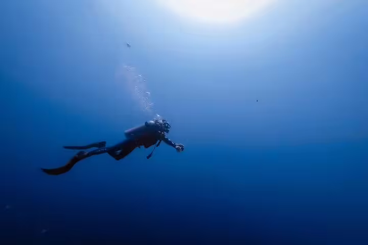 Single scuba diver drifting in deep blue water on Sharks Bay Diving Trip, Red Sea Sharm El Sheikh