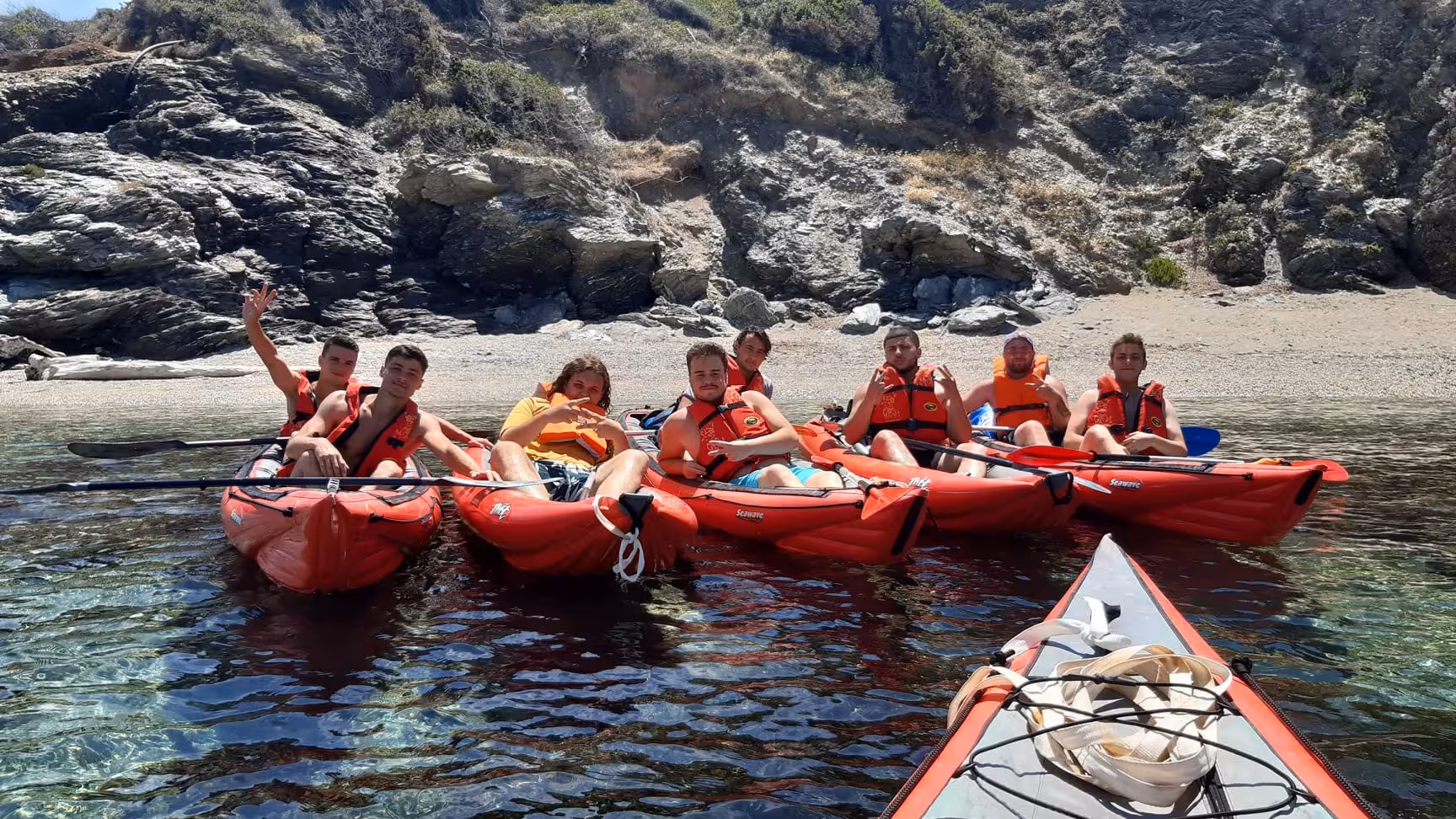 Groupe en kayaks de mer avec gilets en baie rocheuse, excursion naturaliste Embiez vers Cap Sicié