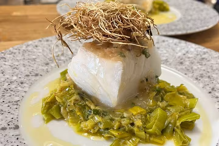 Seared white fish on braised leeks, plated in a Marseille cooking workshop with a local chef and Provençal flavors