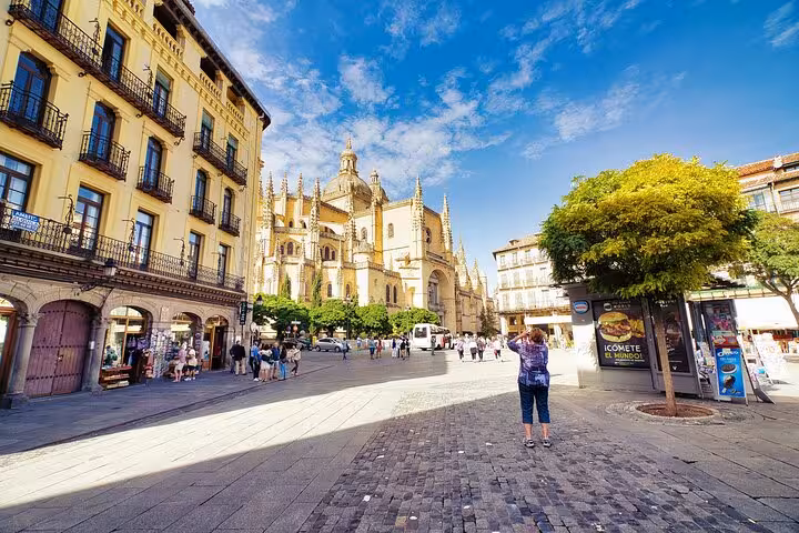 Scenic view of Segovia Cathedral and bustling street captured on a guided tour from Madrid.