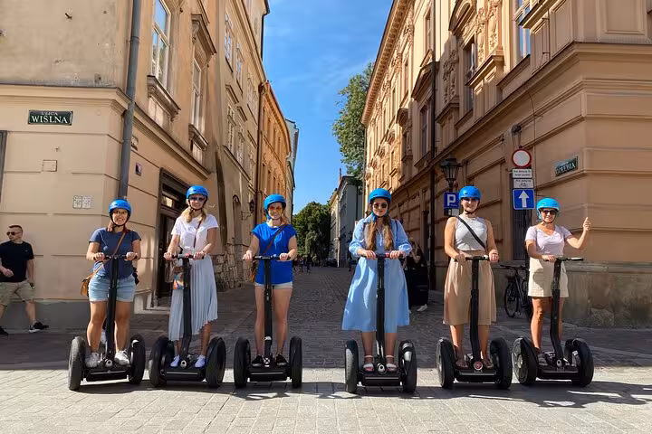Tourists enjoy a sunny Segway ride through Krakow's charming streets, capturing the city's historic ambiance and architecture.