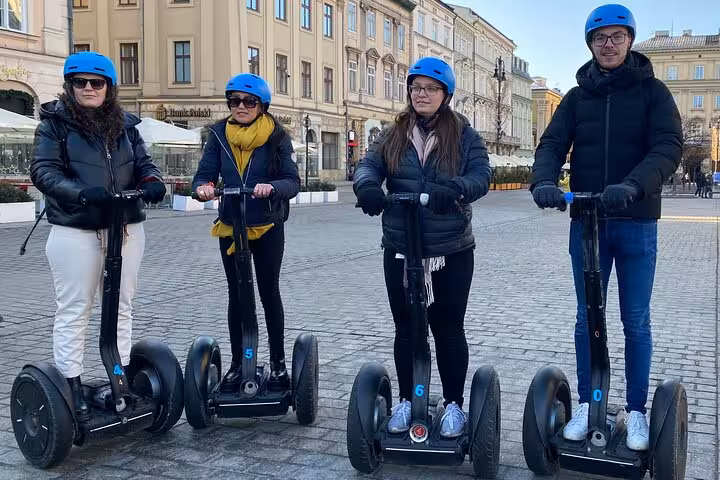 Four individuals on a Segway tour in Krakow, surrounded by the charming architecture of the city center.