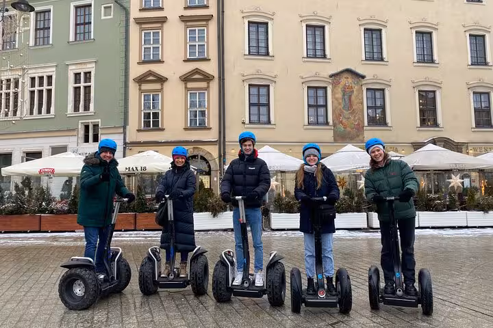 Visitors on a Segway tour in Krakow's scenic square, surrounded by historic buildings and winter atmosphere.