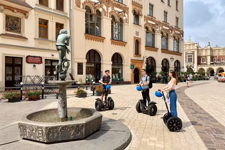Tourists enjoying a Segway tour in Krakow's Jewish Quarter, exploring historic architecture and charming streets.
