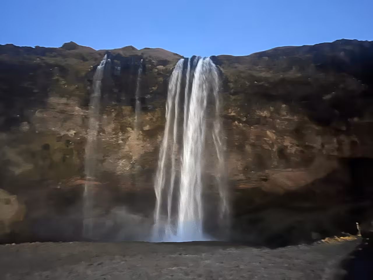 Seljalandsfoss waterfall on Iceland South Coast private tour from Reykjavik, cascading over cliffs in clear sky