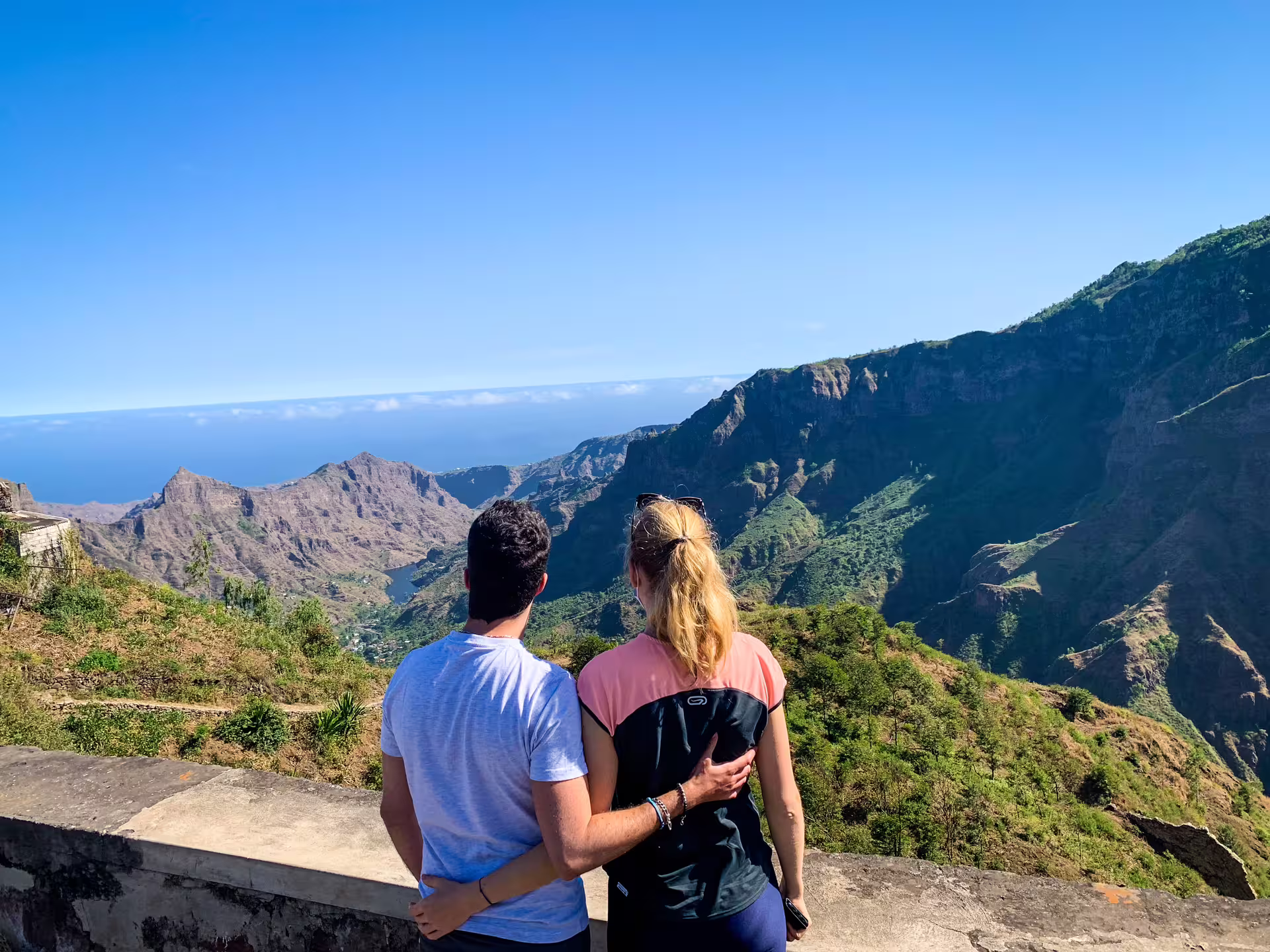 Couple enjoys stunning mountain views at Serra Malagueta Natural Park on a sunny day, ideal for hiking adventures.