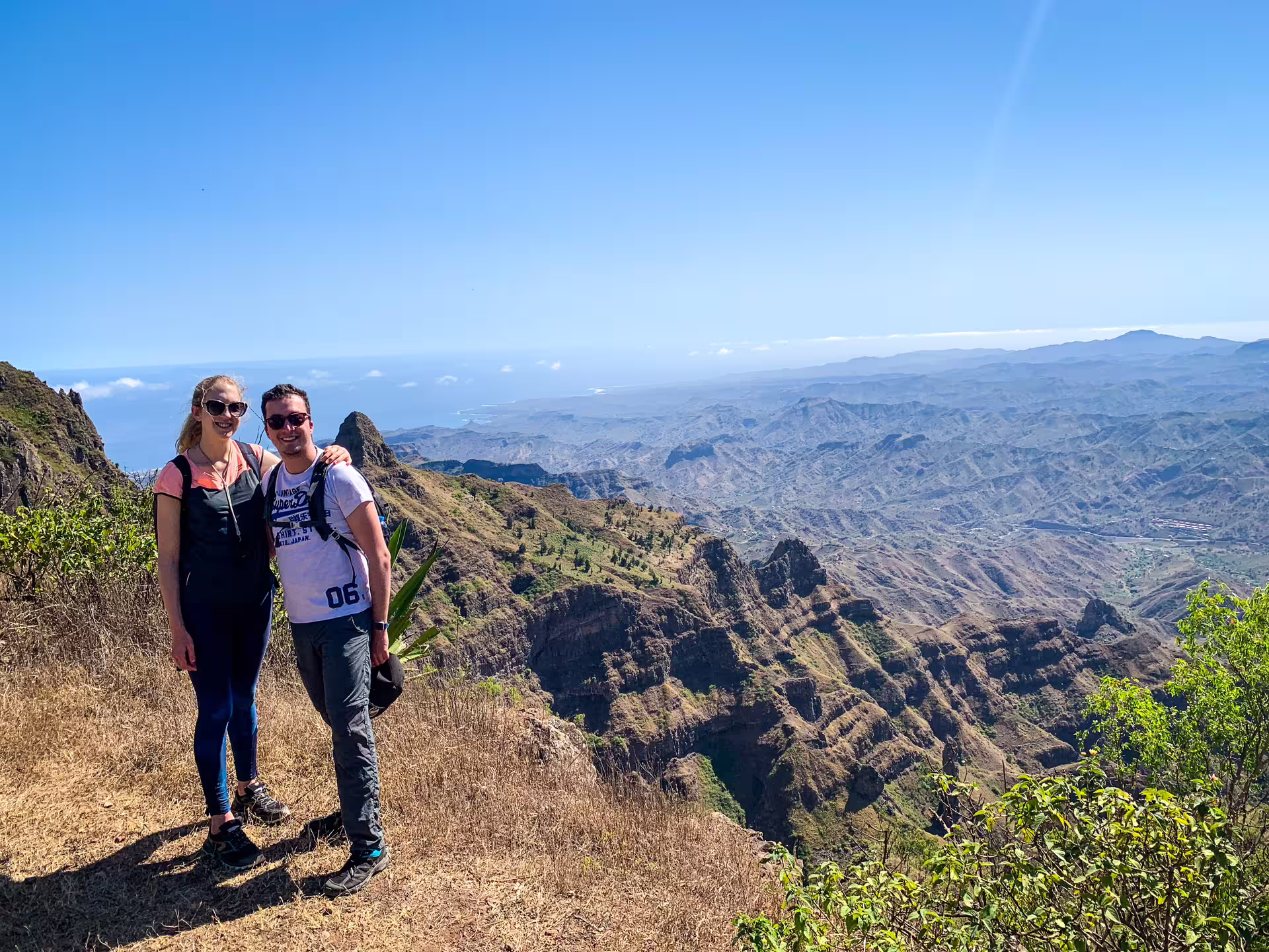 Hikers admire breathtaking Serra Malagueta scenery with expansive mountain views under clear blue skies.