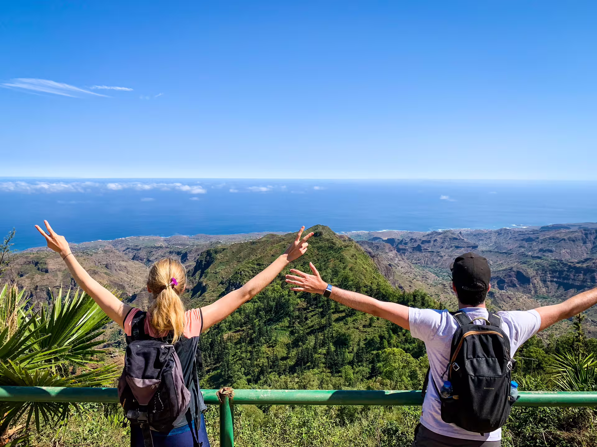 Tourists celebrating at a stunning viewpoint overlooking mountains and sea at Serra Malagueta.
