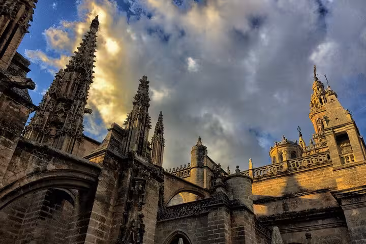 Majestic Gothic architecture of Seville Cathedral under dramatic skies, a highlight of the Galicia Portugal Andalucia tour.