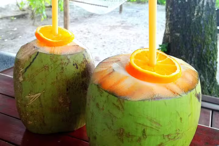 Refreshing coconuts with orange slices and straws, perfect for a tropical Seychelles welcome during airport transfers.
