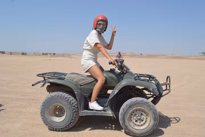 Solo rider on ATV in Sharm El Sheikh desert giving peace sign, quad safari combo with BBQ dinner and show