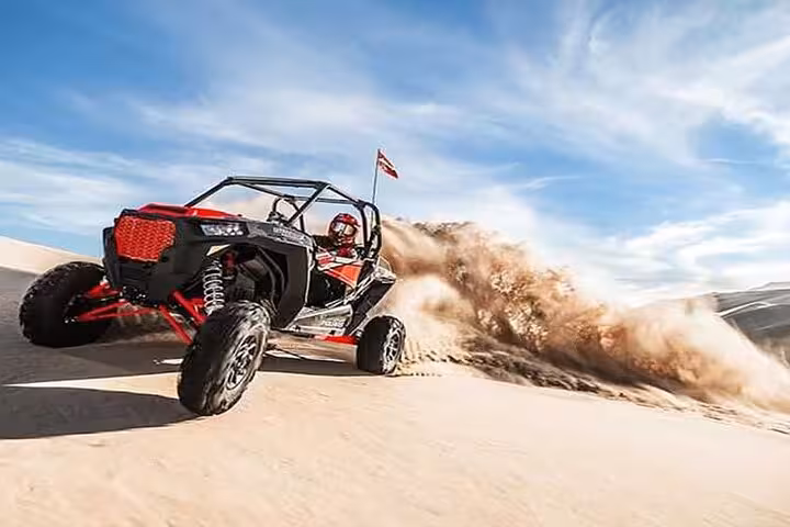 Red dune buggy powers through Sharm El-Sheikh desert dunes on Sinai buggy safari tour with epic sand spray