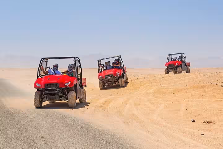 Red UTV convoy crossing Sharm El Sheikh desert on ATV quad safari, part of stargazing and BBQ dinner tour
