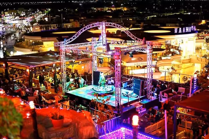 Nightlife view of Sharm El-Sheikh rooftop restaurant with live music stage, shisha and drink included