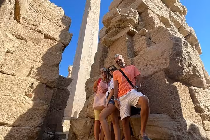 Tourists pose by the Luxor Temple obelisk on a Sharm El Sheikh to Luxor by plane shared group tour