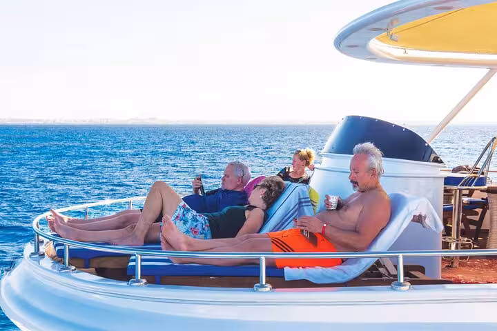 Sunbathing on luxury yacht deck during Sharm VIP cruise to Ras Mohammed and White Island, Red Sea relaxation