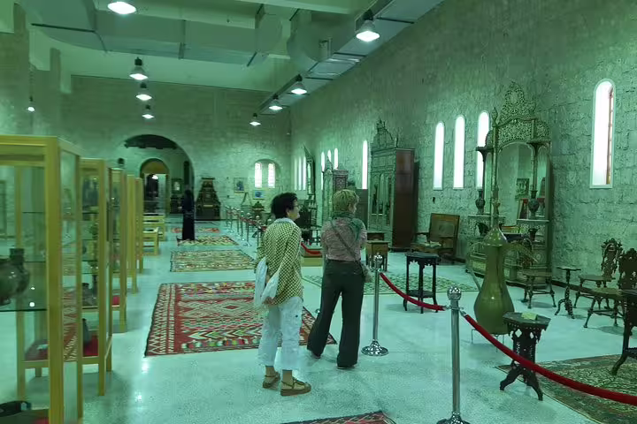 Visitors admire antique furniture and artifacts at the Sheikh Faisal Museum, highlighting Qatar's cultural history.