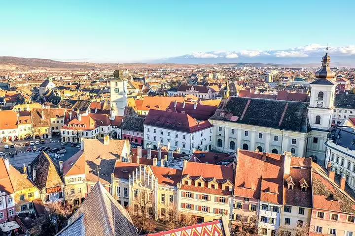 Aerial view of Sibiu old town with red rooftops, historic buildings, and church towers in Transylvania, Romania