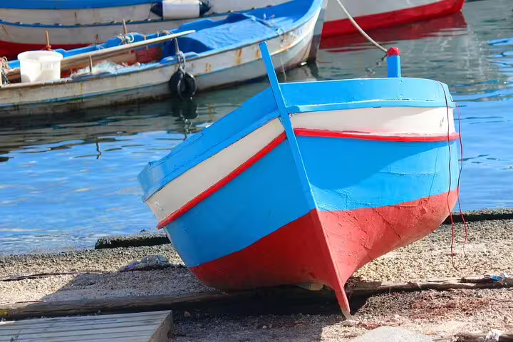 Colorful traditional fishing boat docked by the water in Sicily, perfect for a day trip from Palermo to Segesta, Erice, and Salt Pans.