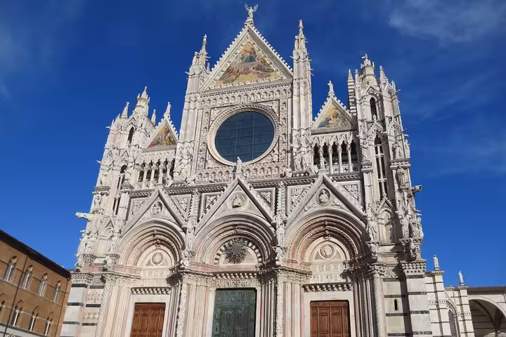 Stunning Siena Cathedral under a clear blue sky, showcasing its gothic architecture on a Tuscany tour.