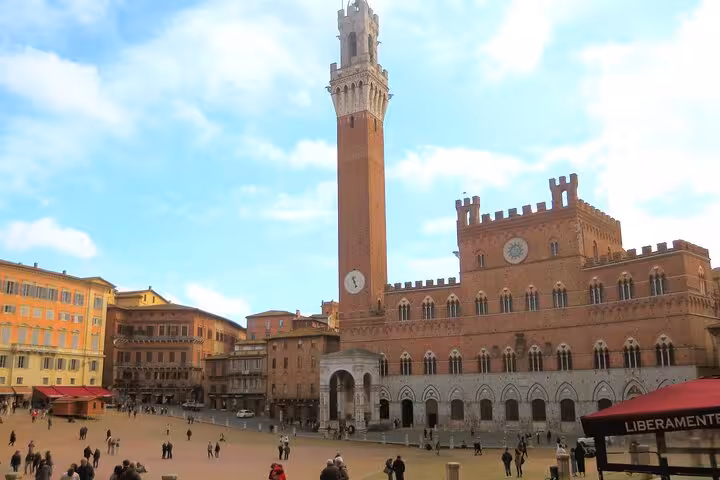 Piazza del Campo in Siena with Torre del Mangia, a vibrant spot for lunch and wine tasting in Tuscany's small group tours.