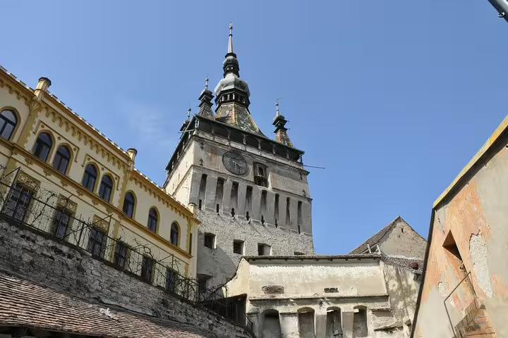 Clock Tower of Sighisoara medieval citadel with baroque spire against blue sky, Transylvania Romania