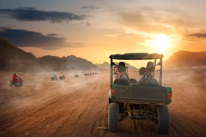 Convoy of buggies and quad bikes crossing Sinai Desert at sunset on a private Sharm El Sheikh adventure tour