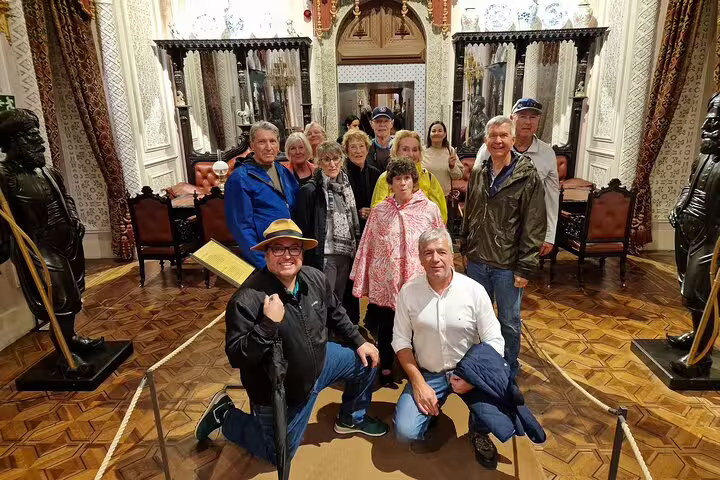 Group of tourists enjoying a private guided tour of Sintra's historic palaces from Lisbon, featuring exclusive monument access.