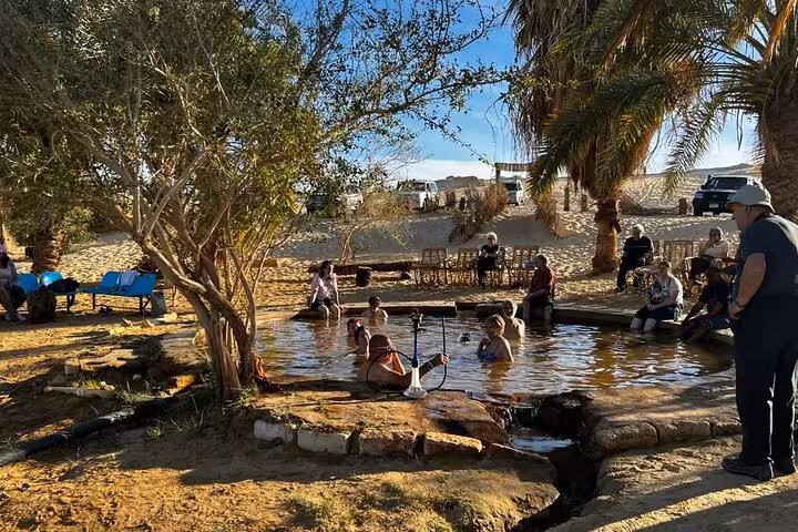 Travelers relaxing in a Siwa Oasis natural hot spring, a highlight of the 3-day Sahara safari tour in Egypt