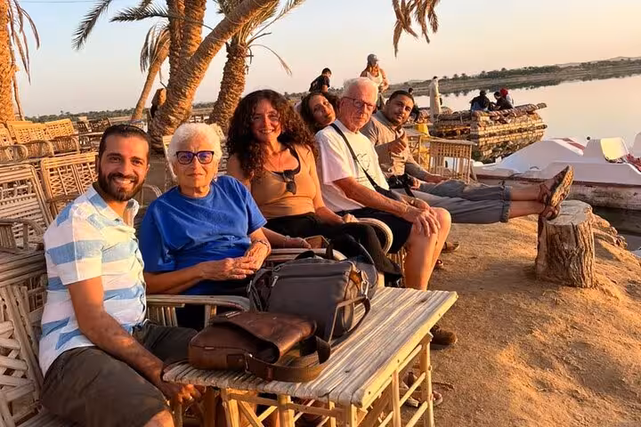 Travelers relax at a Siwa Oasis lakeside camp at sunset on a 3-day Sahara safari with salt lakes and springs