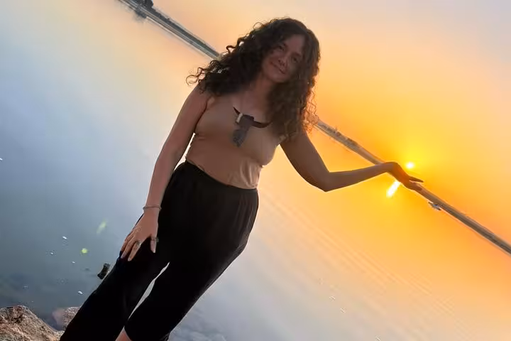 Guest poses by Siwa salt lake at golden sunset during a private 3-day Sahara safari tour with springs and dunes