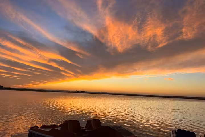 Golden sunset over Siwa salt lake on 3-day Sahara safari, calm water reflections and dramatic clouds