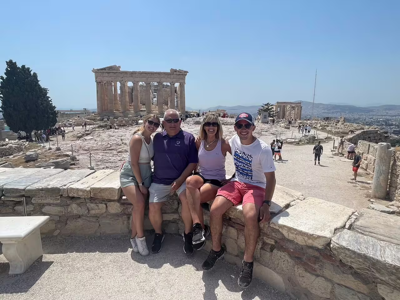 Small group posing on the Acropolis with the Parthenon behind, Athens sightseeing tour with skip-the-line tickets