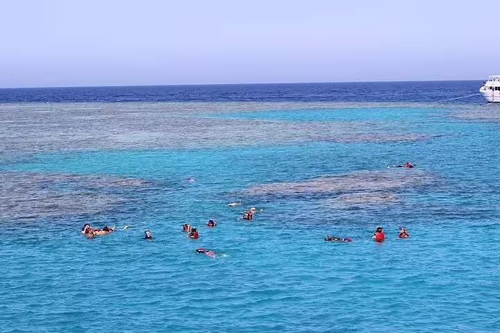 Snorkelers in crystal-clear Sataya Reef lagoon on VIP boat day trip from Marsa Alam, Red Sea