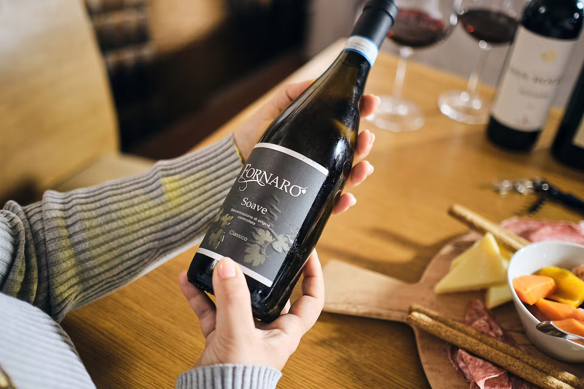 Guest holds Soave Classico bottle for guided Verona wine tasting experience near Juliet’s House with pairings