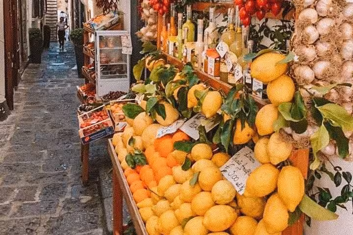 Vibrant display of fresh lemons and local produce in a Sorrento street market, perfect for a limoncello tasting tour.