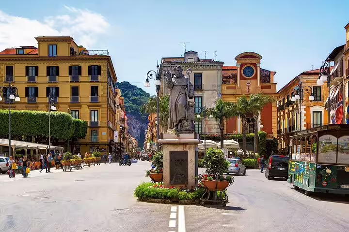 Sorrento main square with statue and colorful buildings, stop on luxury private Amalfi Coast tour from Naples