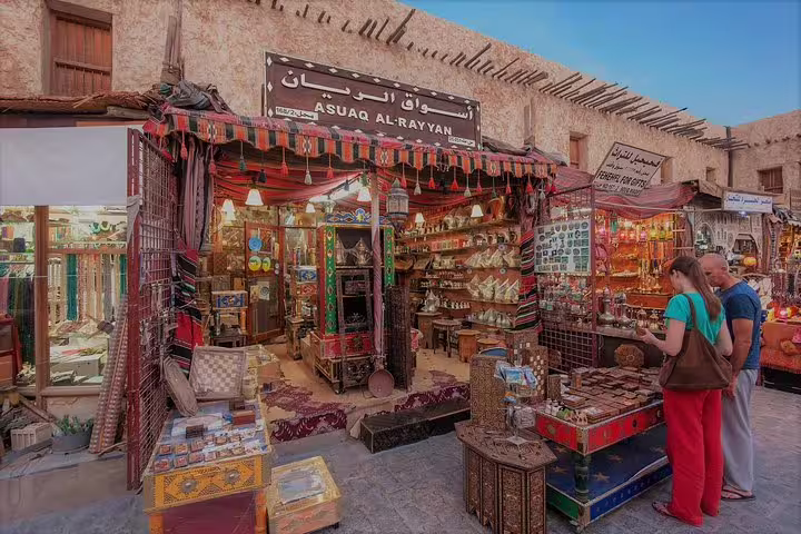 Vibrant Souq Waqif shop display with traditional Qatari crafts and visitors exploring local goods in Doha's cultural market.