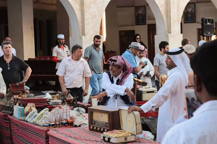 Visitors browsing vintage radios and collectibles at Souq Waqif, highlighting Doha's cultural and market life.